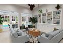 Spacious living room with built-in shelving and pool access at 5146 Damariscotta Pl, Sarasota, FL 34231