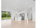 Open concept kitchen with island, stainless steel appliances, and tile flooring at 23246 Stelling Ave, Port Charlotte, FL 33980