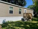 Rear view of a tan mobile home with a wooden deck at 4772 Duncan Rd, Punta Gorda, FL 33982
