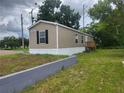 Side view of a tan mobile home with wooden steps at 4772 Duncan Rd, Punta Gorda, FL 33982