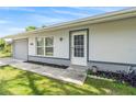 Close up of the entrance to the home, the front door has a white door and storm door at 301 Lambert St, Port Charlotte, FL 33948