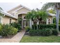 Tan house with white roof, double wood doors, and neatly landscaped yard at 326 Saint George Ct # 14, Venice, FL 34293