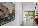Bright hallway with neutral walls, tile flooring, and an open staircase leading to a living area at 2111 Hawthorne St, Sarasota, FL 34239