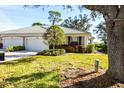 Well-maintained villa with attached two-car garage and lush landscaping at 909 Barclay Ct, Venice, FL 34293