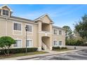 Tan two-story condo building with stairs and landscaping at 9505 Amberdale Ct # 201, Riverview, FL 33578