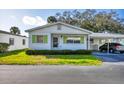 Front view of a single story home with carport and well-manicured lawn at 6033 Arlene Way # 3, Bradenton, FL 34207
