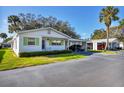 Exterior view of a charming single-story home with a carport and lush landscaping at 6033 Arlene Way # 3, Bradenton, FL 34207