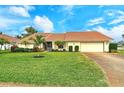 Inviting single-story home features a tile roof, attached garage, and well-manicured lawn at 328 Eden Dr, Englewood, FL 34223