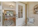 White front door opens to a view of the living room and tiled entryway at 328 Eden Dr, Englewood, FL 34223