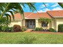 Front view of house with tile roof and lush landscaping at 328 Eden Dr, Englewood, FL 34223
