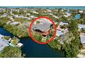 Aerial view of waterfront home with large deck and lush landscaping at 107 Los Cedros Dr, Anna Maria, FL 34216