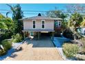 Elevated home with parking underneath and a small balcony at 107 Los Cedros Dr, Anna Maria, FL 34216