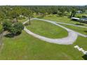 Aerial view of curved driveway and surrounding grassy areas at 34452 Singletary Rd, Myakka City, FL 34251