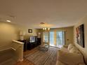 Spacious living room with hardwood floors, a sofa, and access to a balcony at 8807 White Sage Loop # 1903, Lakewood Ranch, FL 34202