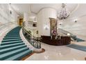 Elegant building lobby with winding staircase, chandelier, marble floors, and reception desk at 35 Watergate Dr # 503, Sarasota, FL 34236