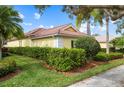 Side view of a yellow house with well-manicured hedges at 5814 Benevento Dr, Sarasota, FL 34238