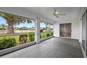 Inviting sunroom featuring tile flooring, large windows with picturesque views of the lake and lush landscaping at 1654 Waxwing Ct, Venice, FL 34293