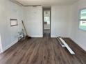 View of a well-lit living room with laminate flooring and white walls, undergoing renovation, with a doorway leading to another room at 2601 Gulf N Dr # 603, Bradenton Beach, FL 34217