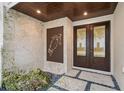 Front entrance with double doors, a stone wall, and a metal turtle design at 5005 Gulf Of Mexico Dr # 5, Longboat Key, FL 34228