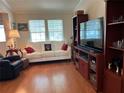 Bright living room with a white couch, red accents, and hardwood floors at 1564 Blind Brook Dr, Sarasota, FL 34234