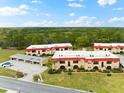 Aerial view of condo community showcasing building arrangement, parking, and surrounding landscape at 209 Rubens Dr # E, Nokomis, FL 34275