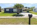 Ranch style home with carport, palm trees and well-maintained lawn at 22283 Catherine Ave, Port Charlotte, FL 33952