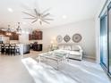 Bright living room featuring a ceiling fan, neutral colors, and sliding doors to the outside at 8678 Rain Song Rd, Sarasota, FL 34238