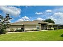 Tan house exterior with screened lanai and lush lawn at 3798 Cedar Hammock Ct, North Port, FL 34287