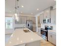 Modern kitchen with gray cabinets, quartz countertops, and an island at 16113 Old Fox Trl, Port Charlotte, FL 33953