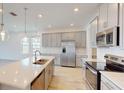 Modern kitchen with gray cabinets, a large island, and stainless steel appliances at 16113 Old Fox Trl, Port Charlotte, FL 33953
