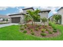 Landscaped front yard with palm trees and well-manicured lawn at 524 Bocelli Dr, North Venice, FL 34275