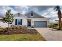 Gray house with gray garage door and landscaping at 16145 Old Fox Trl, Port Charlotte, FL 33953