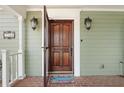 Ornate wooden front door with a screen door and welcome mat at 7754 Westmoreland Dr, Sarasota, FL 34243