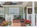 Front porch with white railings, brick flooring, and potted plants at 7754 Westmoreland Dr, Sarasota, FL 34243