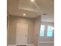 View of the home's light-filled entryway with a white door and sleek design, complemented by a glimpse into the kitchen at 13126 Marathon Blvd, Port Charlotte, FL 33981