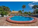 Community pool with lounge chairs and palm trees at 3411 Clark Rd # 212, Sarasota, FL 34231
