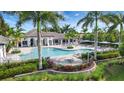 Community pool with a hot tub, lounge chairs, and palm trees at 2638 Light Sky Ln, Bradenton, FL 34211