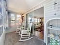 Enclosed porch with rocking chairs and view into the living room at 3333 26Th E Ave # 1099, Bradenton, FL 34208