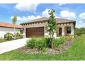 Lovely home featuring a tile roof, two-car garage, and well-maintained lawn with green bushes at 305 Potenza Loop, Nokomis, FL 34275