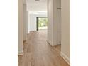 Light and airy hallway with wood-look flooring and views of the outdoor space at 305 Potenza Loop, Nokomis, FL 34275