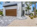 Modern home with wood garage door and paver driveway at 111 Gull Dr, Anna Maria, FL 34216