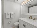 Clean bathroom with white vanity, gold fixtures, and mirror at 5780 Midnight Pass Rd # 710, Sarasota, FL 34242