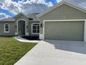 Newly built home with light green exterior and two-car garage at 8233 Givlic Ln, North Port, FL 34287