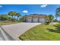 Tan house with three-car garage and a large paved driveway at 2009 Calusa Lakes Blvd, Nokomis, FL 34275