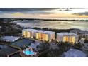 Waterfront condos featuring a pool, tennis courts, and stunning views of the bay at sunset at 280 Hidden Bay Dr # 203, Osprey, FL 34229