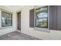 Front entry with dark brown door and window shutters at 100 Corserra Dr, Nokomis, FL 34275