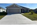 Exterior of a home with a smooth concrete driveway leading to a two car garage at 2600 Averland Loop, North Port, FL 34287