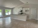 Bright kitchen featuring white cabinets, stainless steel appliances, and a granite countertop island at 2679 Englewood Rd, Venice, FL 34293