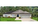 One-story home with gray siding, dark roof, and two-car garage at 855 Cumberland Rd, Venice, FL 34293