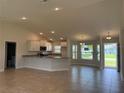 Open concept living room and kitchen with recessed lights and tile flooring at 855 Cumberland Rd, Venice, FL 34293
